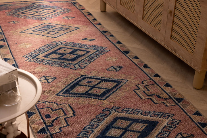 Handmade 3.5x9.9 ft wool and cotton runner rug in pink and navy with bohemian geometric patterns.