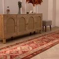 Handmade 2.9x12.5ft wool and cotton runner rug in red and brown with a bohemian geometric floral pattern.