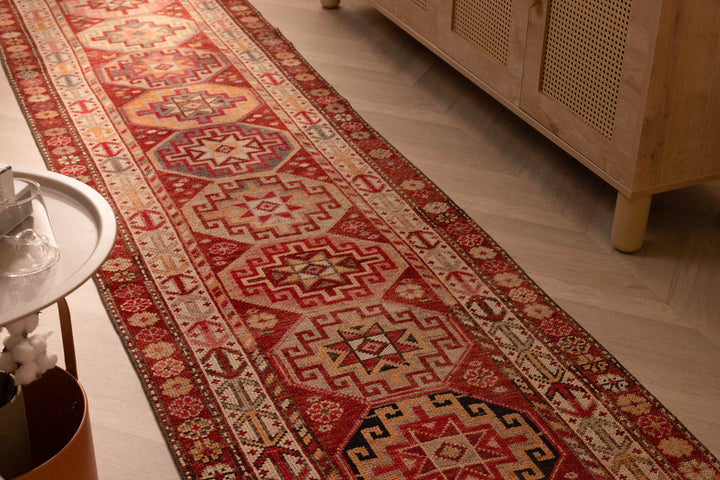 Handmade 2.9x12.5ft wool and cotton runner rug featuring red and brown geometric floral patterns in a bohemian style.