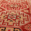 Handmade wool and cotton runner rug in red and brown with geometric bohemian patterns.