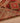 Handmade wool and cotton Persian-style runner rug in red and brown with geometric floral patterns and tasseled edges.