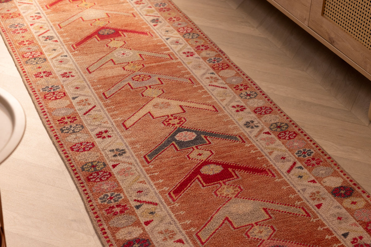 Handmade 2.5x13.4 ft wool and cotton runner rug in brown and beige with a maximalist Persian-style geometric floral pattern.