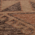 Close-up of a vintage hand-woven Turkish runner rug with orange and gray geometric patterns in wool and cotton.