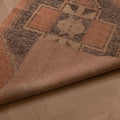 Hand-woven vintage Turkish runner rug in burnt orange and gray with geometric patterns on a wooden floor.