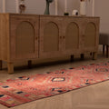 Handmade pink wool and cotton runner rug with bohemian geometric patterns, 2.4 x 10.5 ft, placed on a wooden floor.