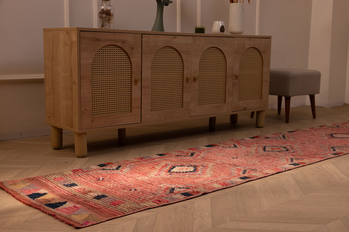 Handmade pink wool and cotton runner rug with bohemian geometric patterns, 2.4 x 10.5 ft, placed on a wooden floor.