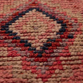 Handmade pink wool and cotton runner rug featuring a geometric Southwestern pattern with a low-pile texture.