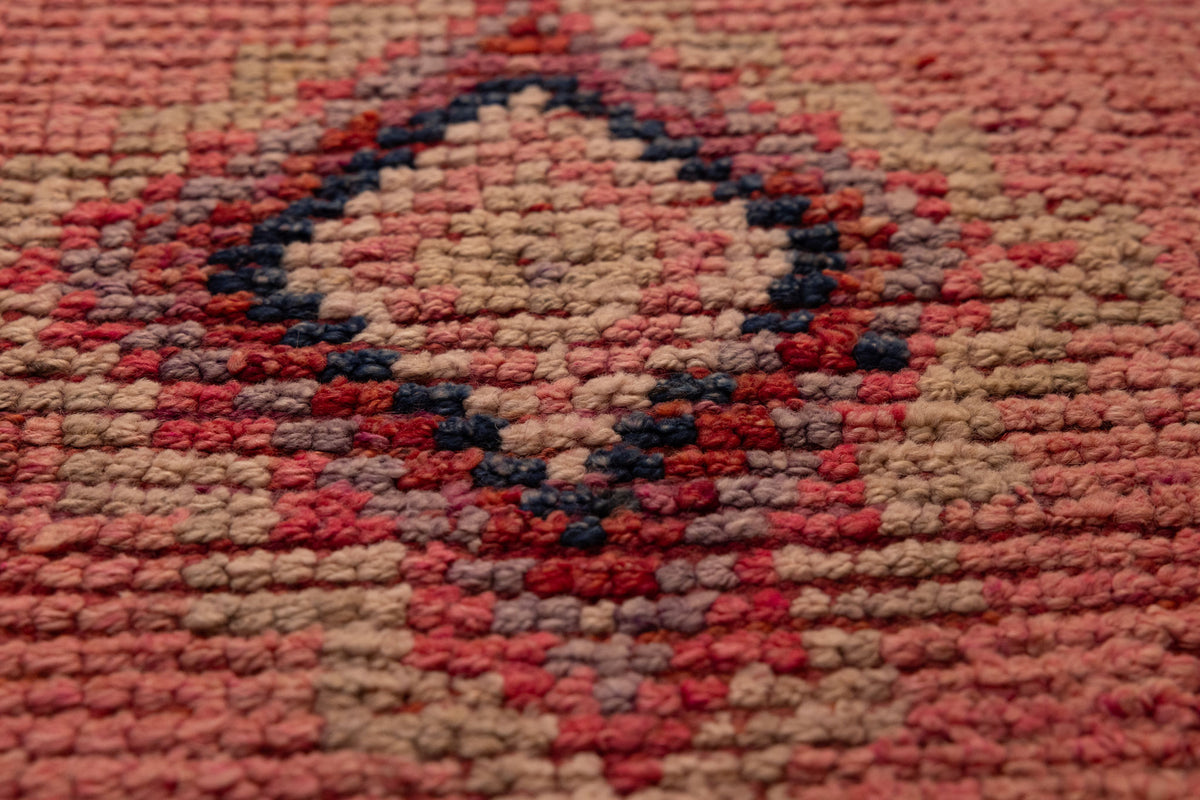 Handmade pink wool and cotton runner rug featuring a geometric Southwestern pattern with a low-pile texture.