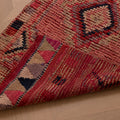 Handmade pink Persian-style wool and cotton runner rug with geometric southwestern patterns.