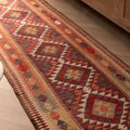 2.9x14 ft handmade wool and cotton Persian-style Kilim runner in brown and orange with geometric maximalist patterns.