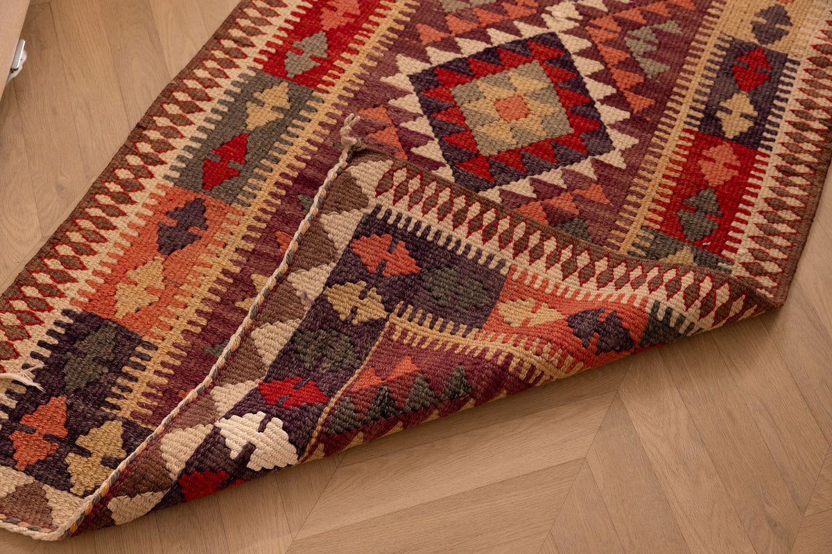 Handmade 2.9x14 ft Persian-style wool and cotton Kilim runner with geometric maximalist patterns in brown and orange.