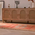 Hand-woven orange vintage Sivas Turkish wool runner rug with floral patterns on a light wood floor.