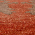 Close-up of a handmade wool Sivas runner rug featuring burnt-orange and brown floral patterns with a low-pile texture.