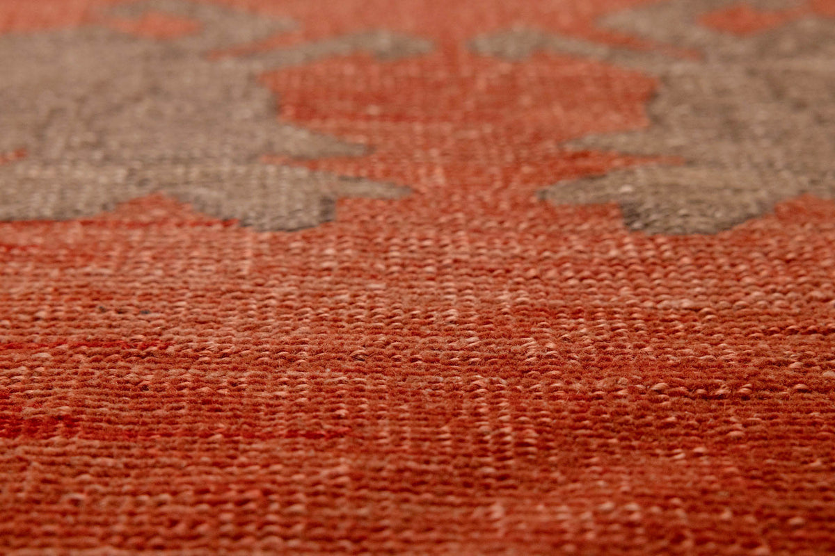 Close-up of a handmade wool Sivas runner rug featuring burnt-orange and brown floral patterns with a low-pile texture.