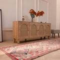 Handmade pink and gray wool-cotton Persian-style Kilim runner rug with geometric patterns in a bohemian living room.