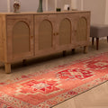 Handmade pink Persian-style wool and cotton runner rug with geometric patterns, 2.9 x 11.1 ft, in a bohemian interior.