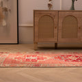Handmade pink Persian-style wool and cotton runner rug with geometric patterns on a wooden floor.
