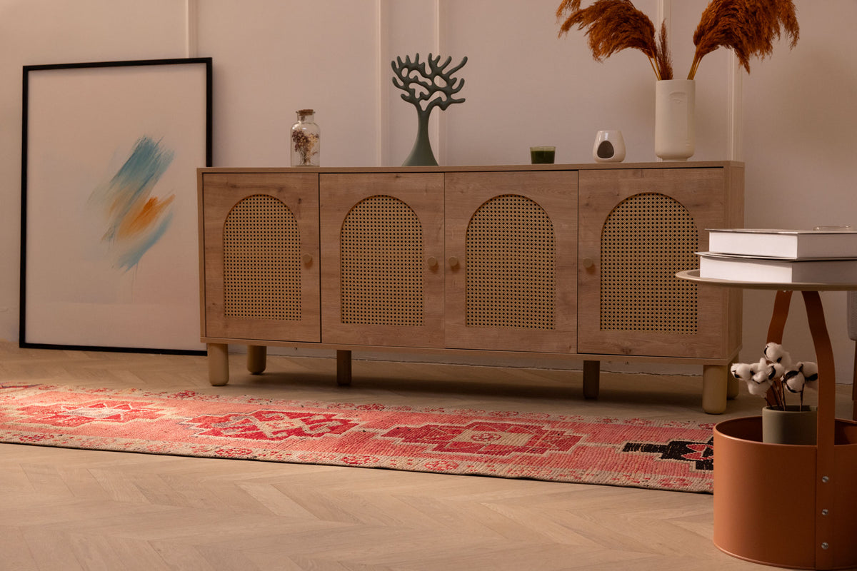 Pink Persian-style wool and cotton runner rug with geometric patterns in a bohemian living room setting.