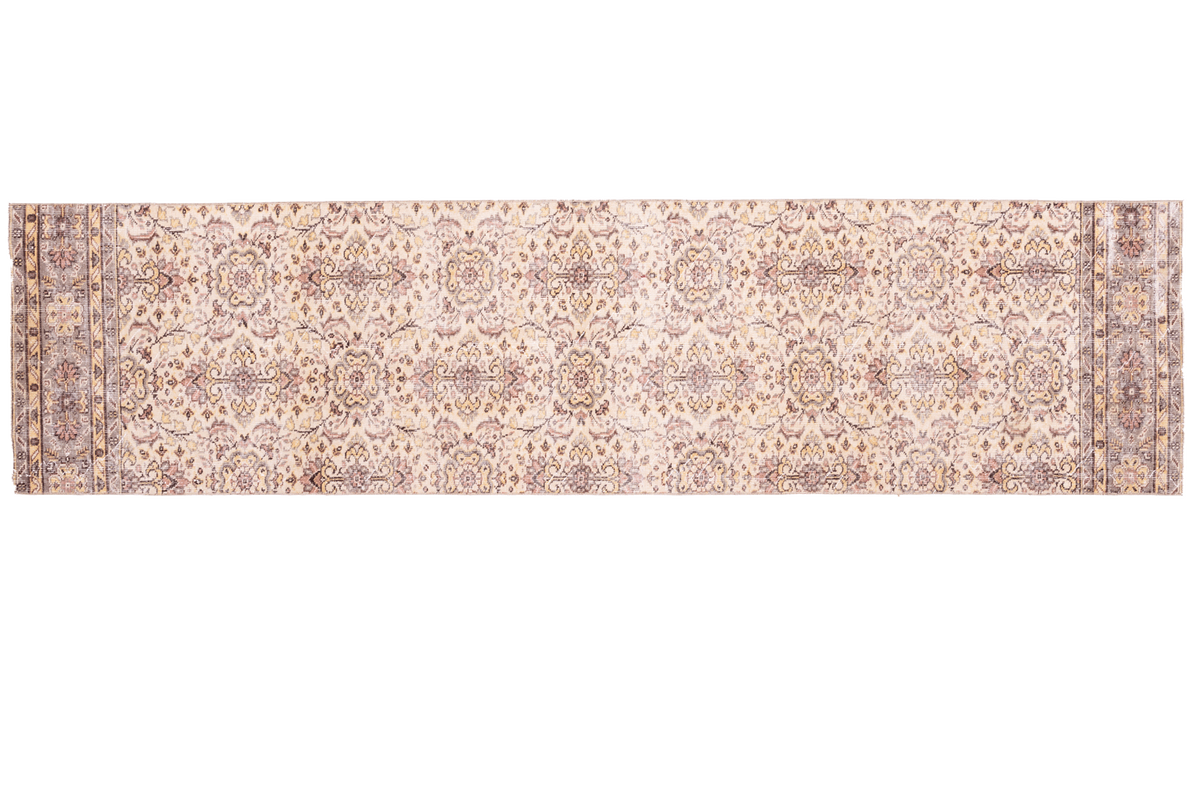 Long rectangular beige rug with intricate patterns on a white background