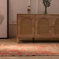 Handmade pink and brown Persian-style wool and cotton runner rug with geometric patterns on a wooden floor.