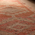 Handwoven pink and brown wool-cotton runner rug featuring geometric patterns in a bohemian Persian style.
