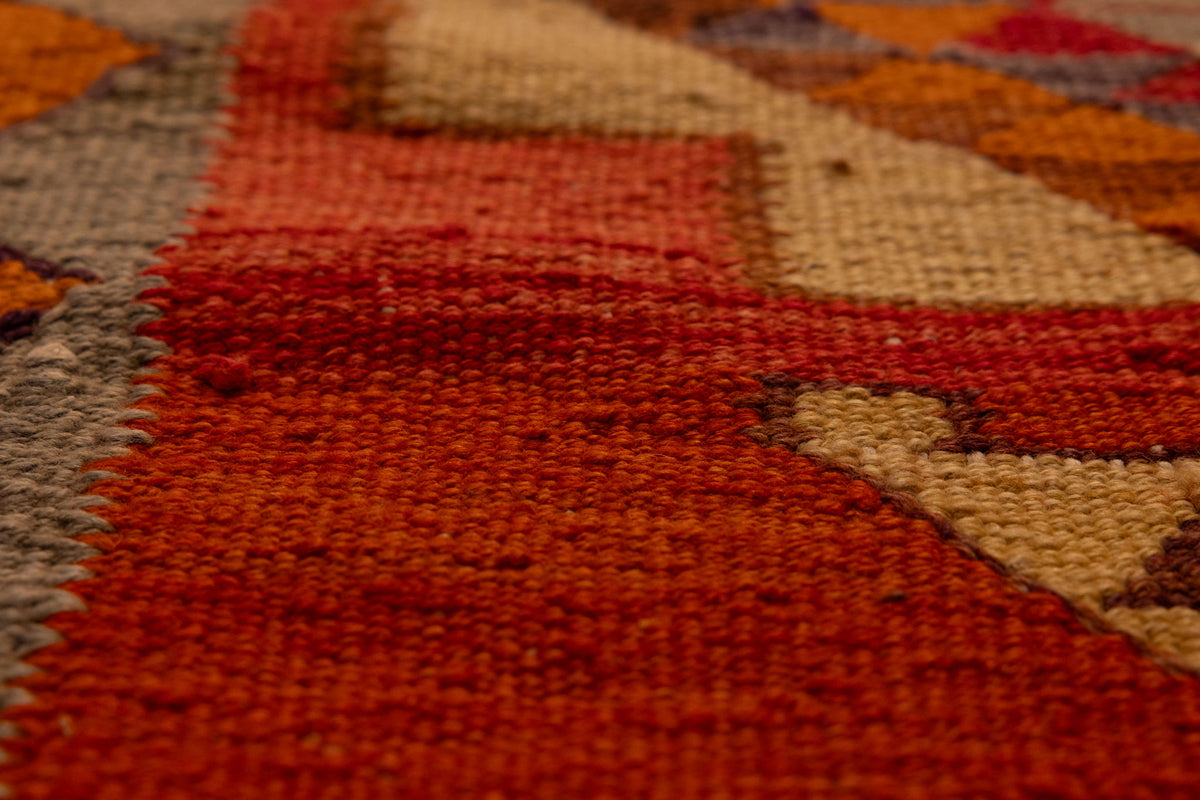 Handmade Persian-style wool and cotton Kilim runner with red and orange geometric patterns and flatweave texture.