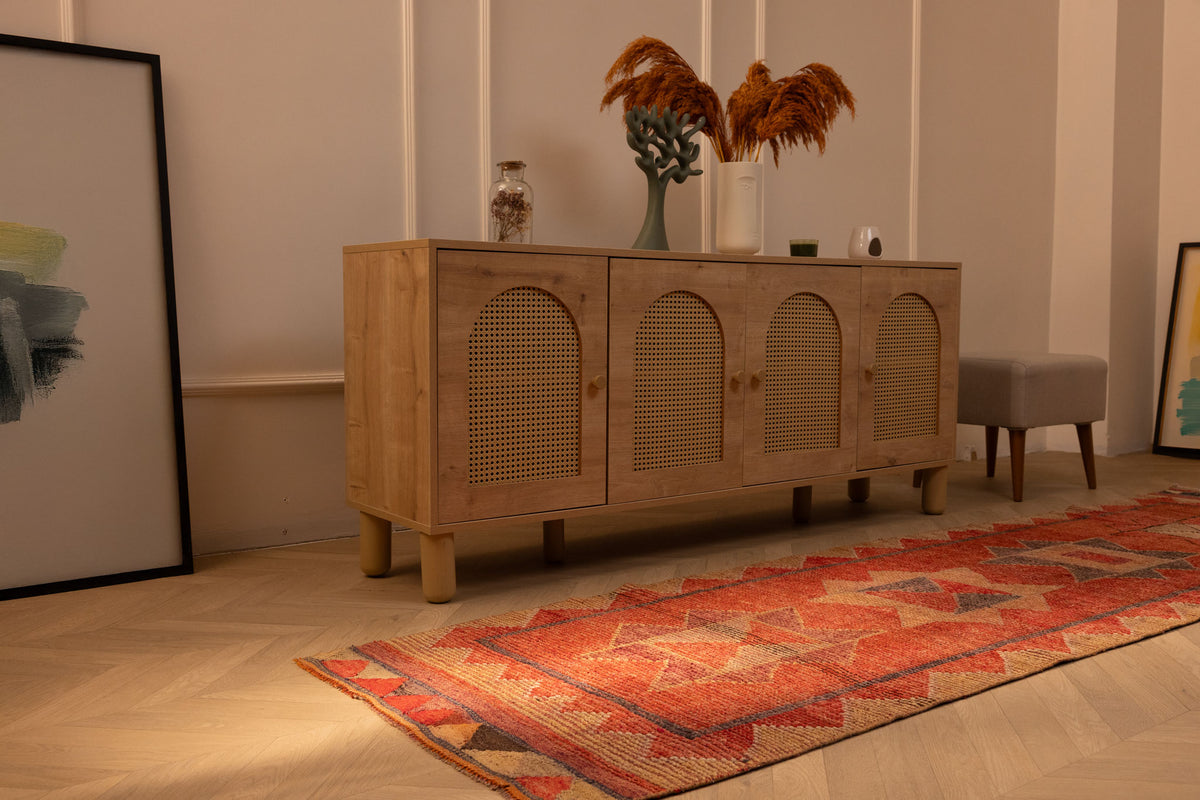 Handmade pink and beige Persian-style wool and cotton runner rug with geometric patterns on a wooden floor.