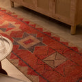 Handwoven pink and beige wool-cotton Persian runner rug with geometric patterns, 2.8 x 10.4 ft, in a bohemian interior.