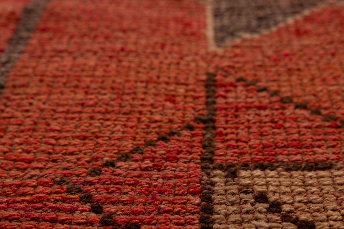 Close-up of a pink and beige wool-cotton Persian runner rug with geometric patterns and a textured low-pile weave.