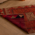 Handmade pink and beige wool-cotton Persian runner rug with geometric patterns on a wooden floor.