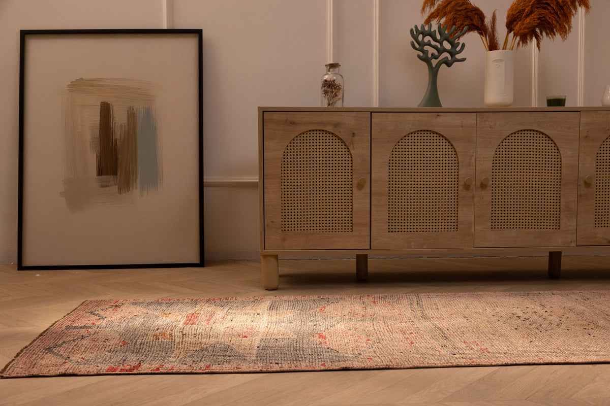 Handmade pink and brown Persian-style wool and cotton runner rug with geometric patterns in a bohemian living room.