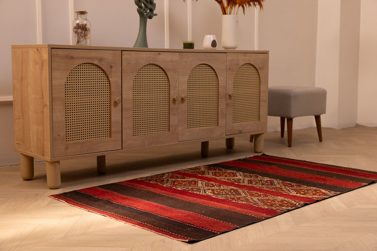 Handmade 3x5 ft vintage Turkish wool kilim rug in red and brown with geometric patterns on a wooden floor.