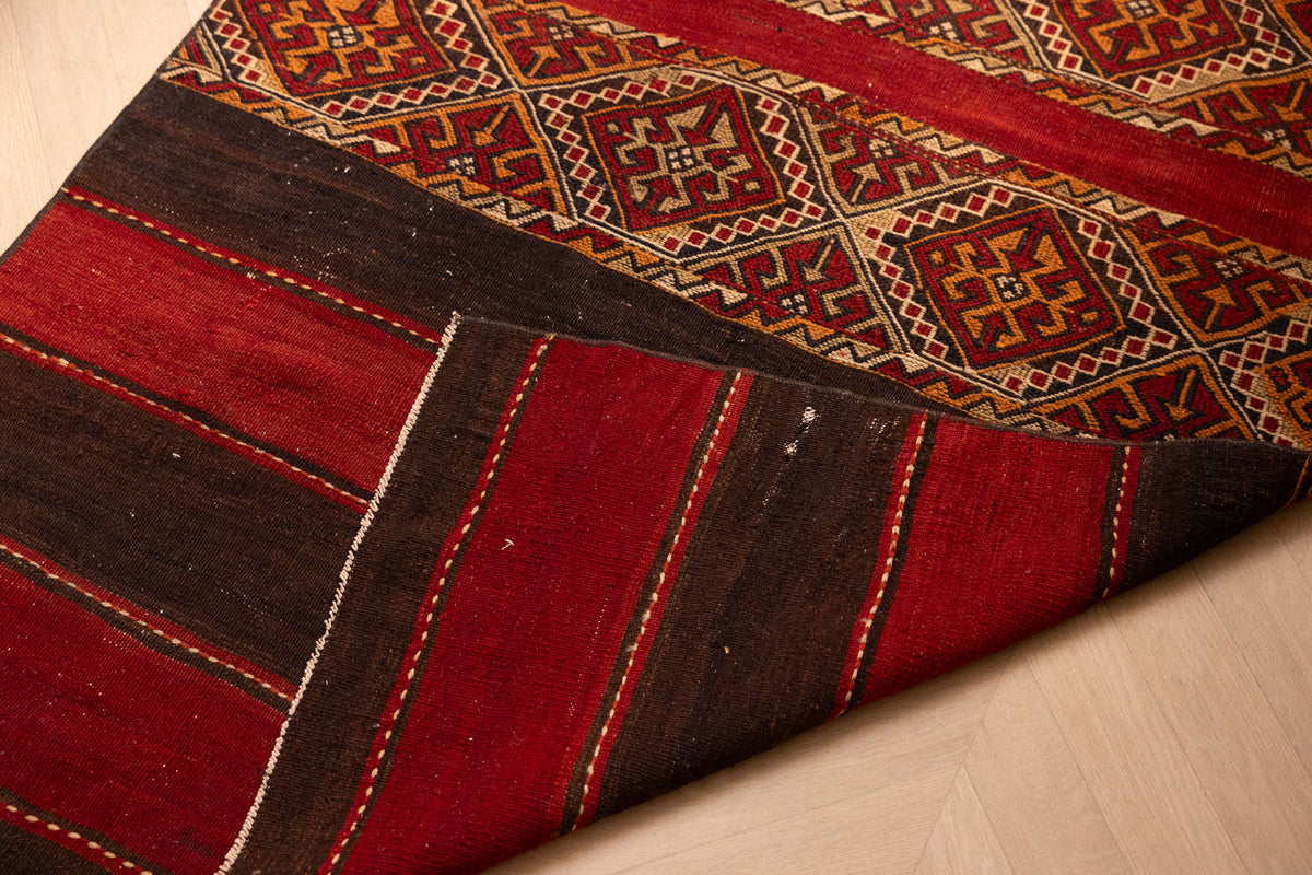 Hand-woven 3x5 ft Turkish wool kilim rug featuring red and brown geometric patterns and a rustic flatweave design.