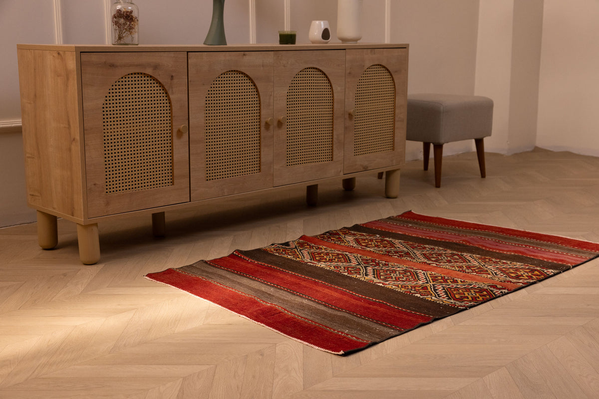 Handmade 3x4 ft vintage Turkish wool kilim rug featuring red and brown geometric patterns on a herringbone floor.