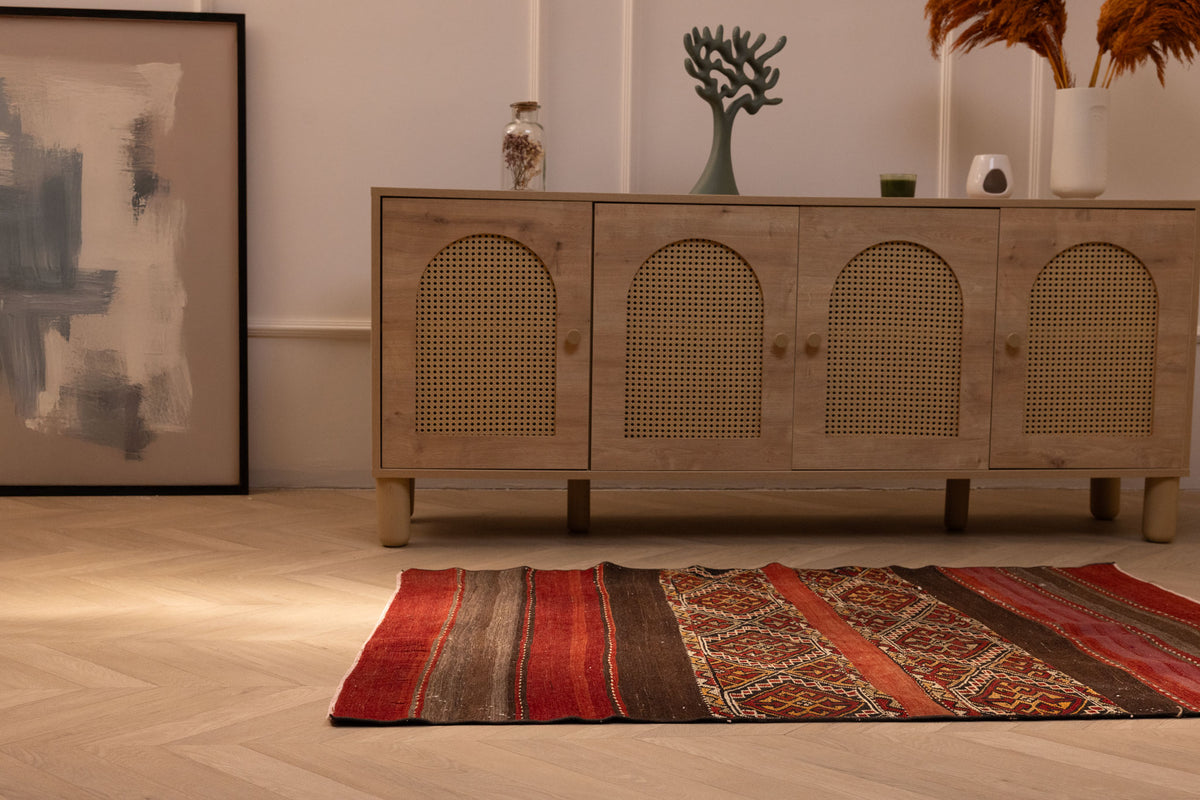 Handmade 3x4 ft wool Turkish kilim rug in red and brown with geometric patterns on a light wood floor.