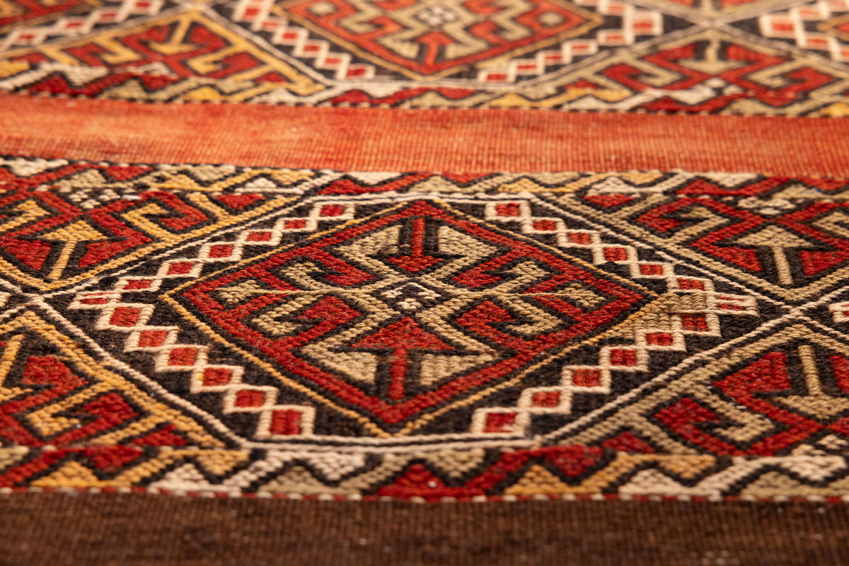 Hand-woven vintage Turkish wool rug with red and brown geometric patterns in a 3x4 ft flatweave design.