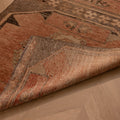Handwoven vintage Turkish runner rug in orange and brown with geometric patterns, crafted from wool and cotton.