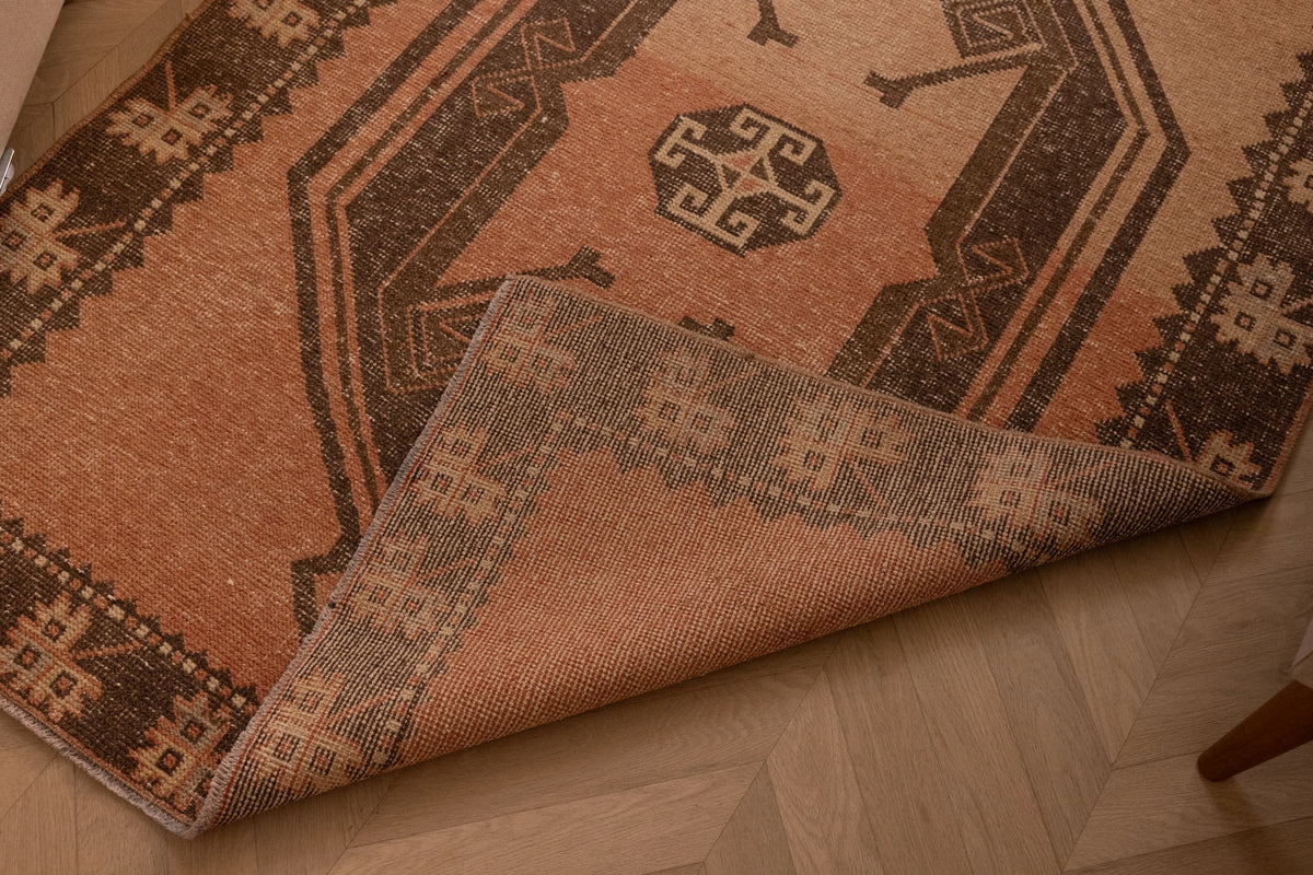 Handmade 4x14 ft vintage Turkish runner rug in orange and gray with geometric patterns, crafted from wool and cotton.