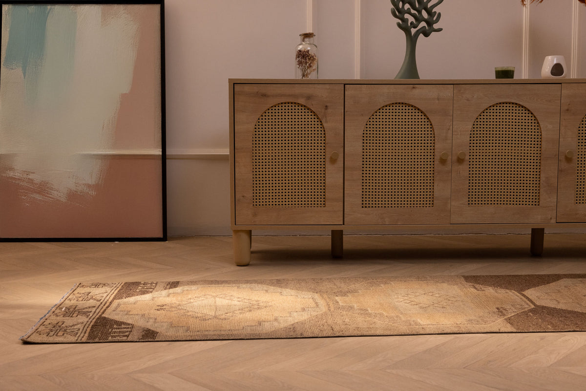 Vintage 2x9 ft Turkish runner rug in beige and brown wool with geometric patterns on a herringbone wood floor.