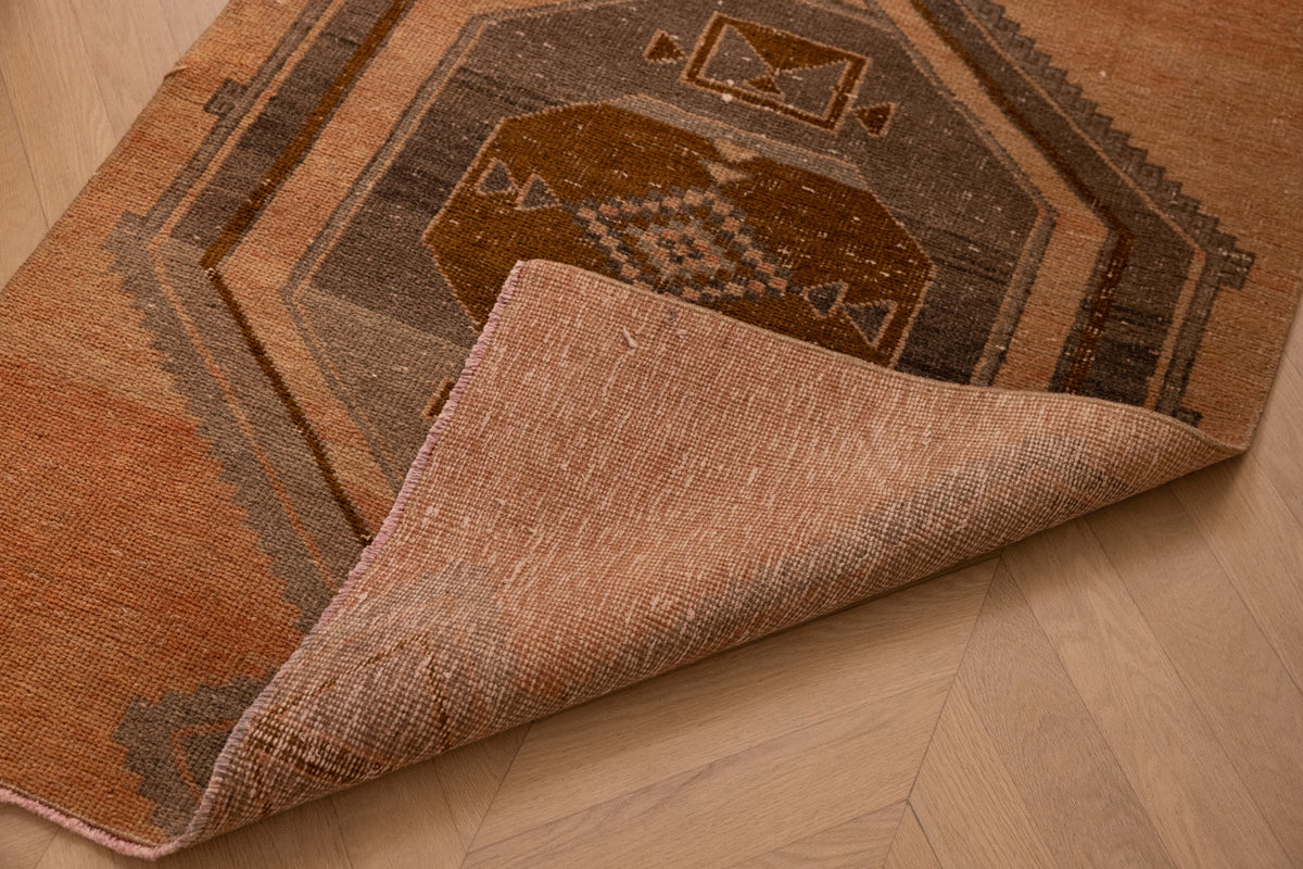 Handwoven 3x12 ft vintage Turkish runner rug in orange and gray with geometric patterns and wool-cotton blend.