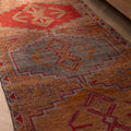 Handmade 3.4 x 10.3 ft wool and cotton Persian-style runner rug featuring orange and brown geometric bohemian patterns.