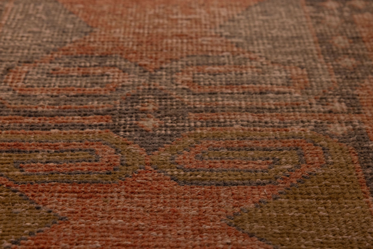 Handwoven vintage Turkish runner rug in brown and orange with geometric patterns and a textured wool-cotton blend.