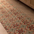 Vintage Isparta wool and cotton runner rug in beige and green with floral patterns on a herringbone floor.