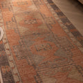 Hand-woven 3x11 ft vintage Turkish runner rug in burnt orange and gray with geometric tribal patterns.
