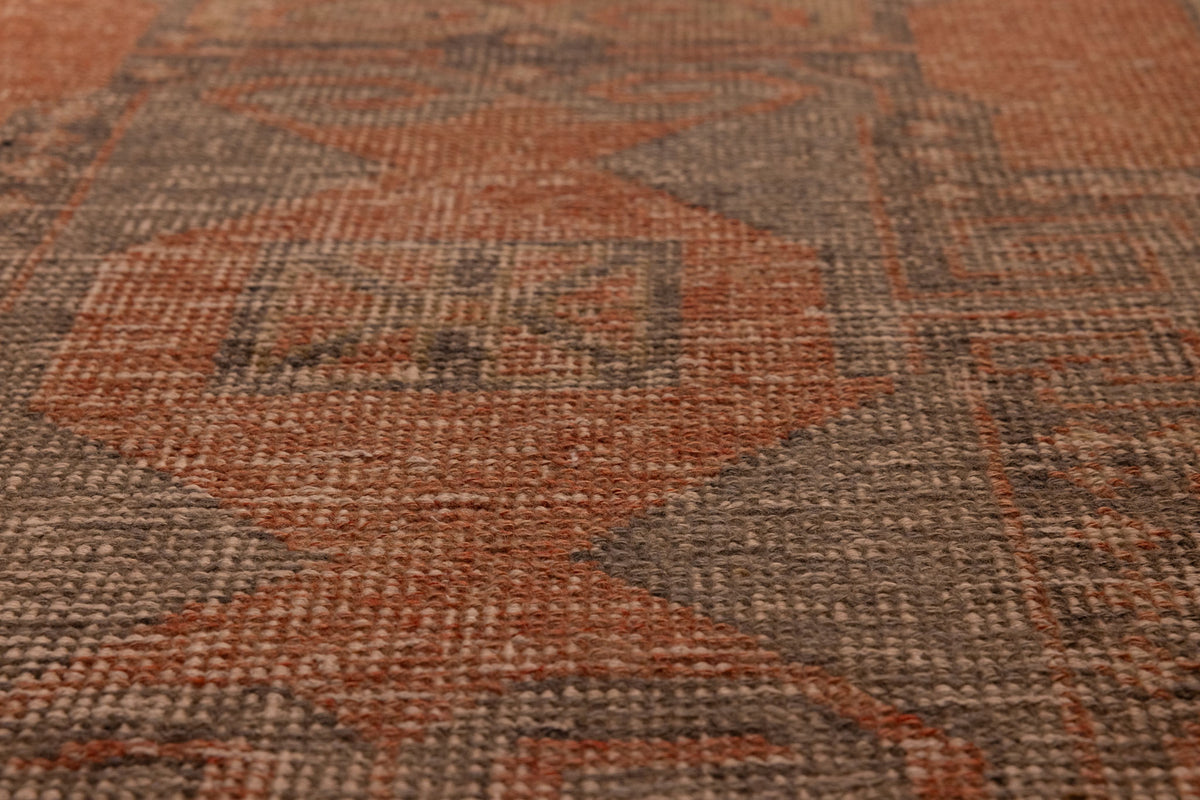 Hand-knotted vintage Turkish runner rug in burnt orange and smoky gray with geometric tribal patterns.