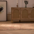 Handmade pink and beige wool-cotton Persian style runner rug with geometric patterns on a wooden floor.
