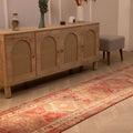 Handwoven brown and red Persian style wool-cotton runner rug with floral patterns in a bohemian living room.