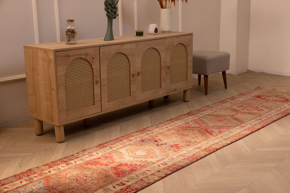 Handwoven brown and red Persian style wool-cotton runner rug with floral patterns in a bohemian living room.