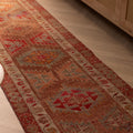 Handmade brown Persian-style wool and cotton runner rug featuring maximalist floral and geometric patterns.