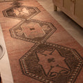 Handwoven 3x11 ft vintage Turkish runner rug in brown and orange with geometric tribal patterns and wool-cotton blend.